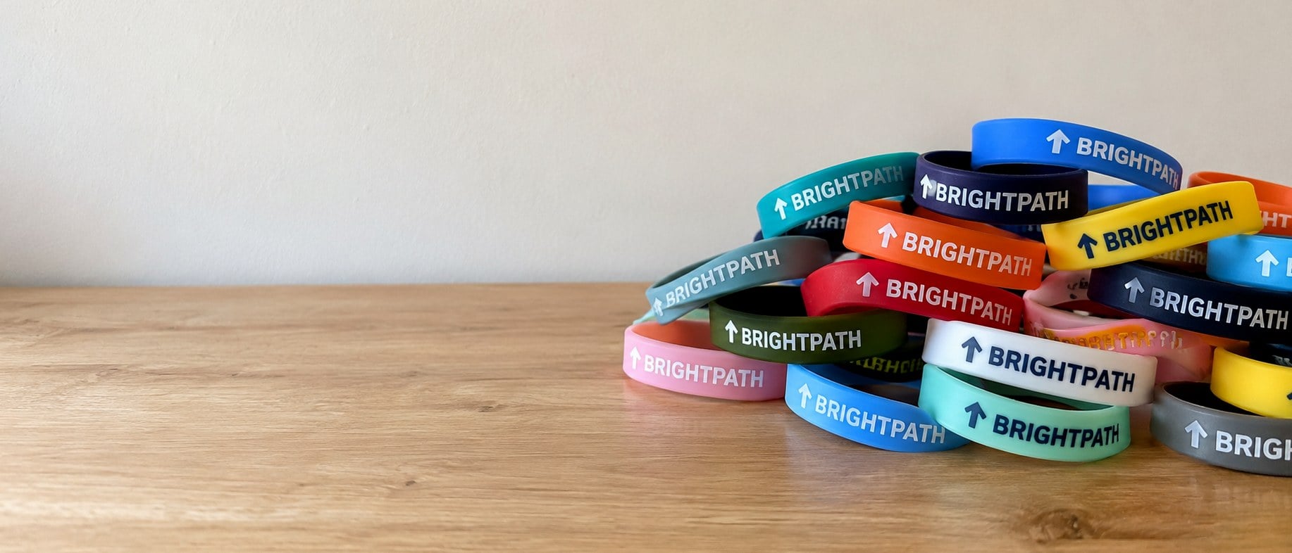 Custom silicone bracelets in bulk in many colors spread across a table